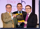 David Smithson, left, and Stepehen Kinkead, right, accept the UC's Excellence award from Mark Lewis